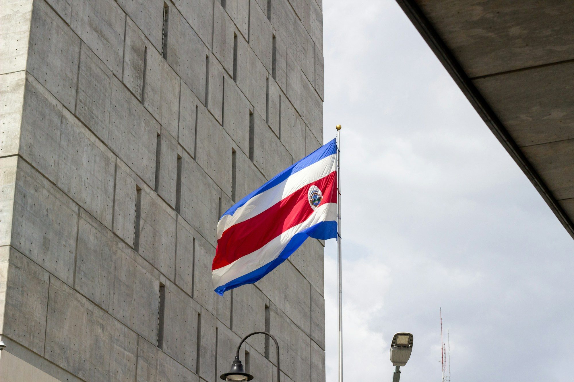 Bandera de Costa Rica ondeando junto a un edificio moderno